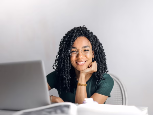 happy ethnic woman sitting at table with laptop stockpack pexels